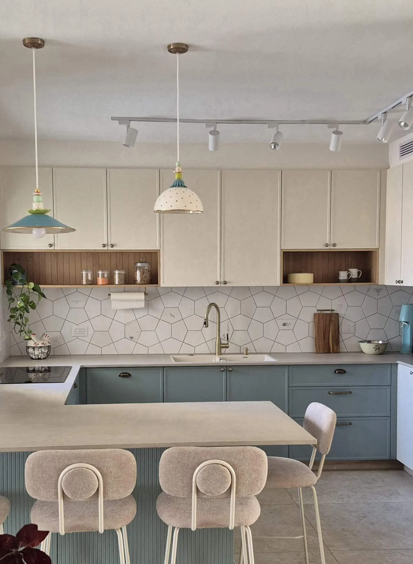 Kitchen with a breakfast bar, blue-grey lower cabinets, and pendant lights.