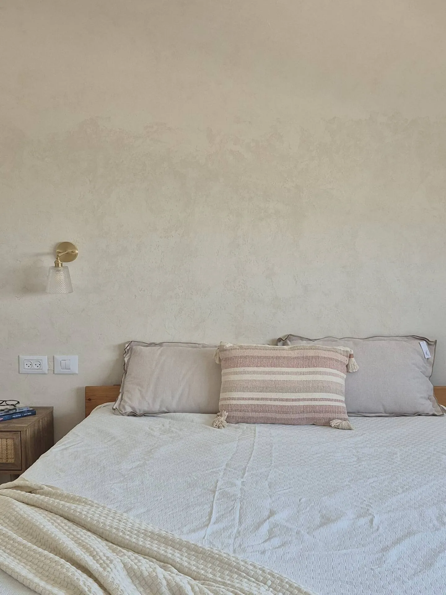 Bedroom with a double bed and striped cushions.