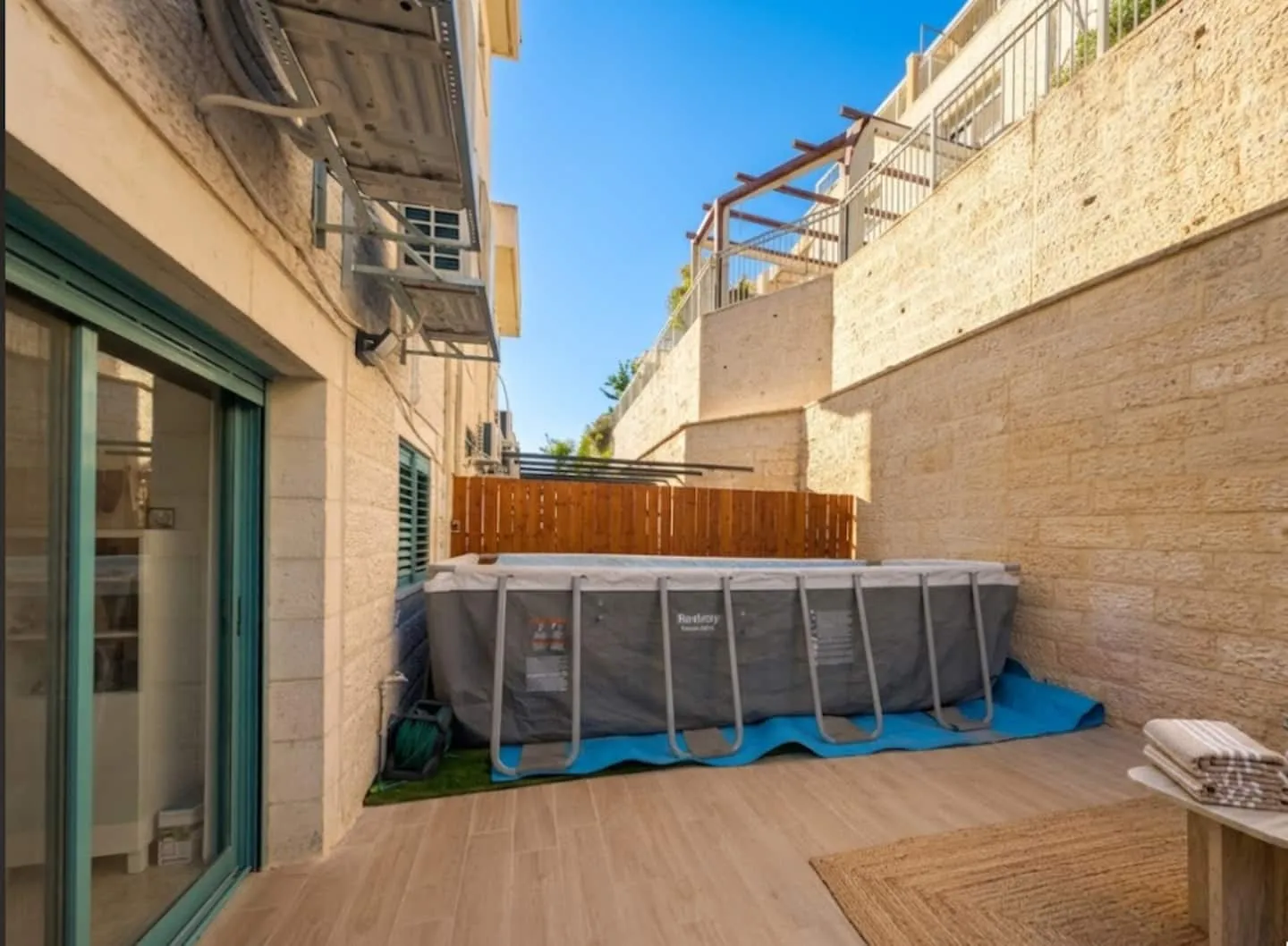 Side yard with a seasonal above-ground pool and decking.